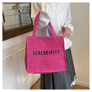 Detail of hot pink crochet tote bag featuring embroidered Serendipity lettering