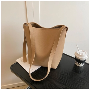 Close-up of minimalist khaki bucket bag with lychee texture and HOCOMU logo detail