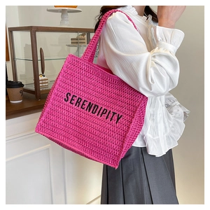 Close-up of pink crochet tote bag featuring black SERENDIPITY text in a cafe setting