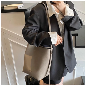 Close-up of pebble leather bucket bag in elephant grey with adjustable shoulder strap