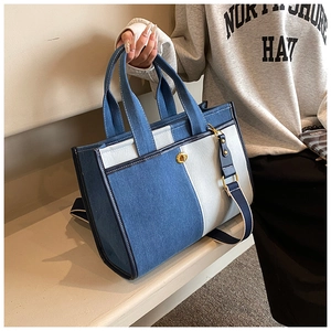 Detail of a minimalist denim patchwork crossbody bag with a round golden twist lock
