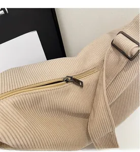 Close-up of smooth metal zipper and ribbed corduroy texture on apricot shoulder bag