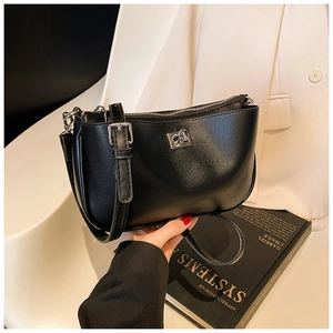 Detail of premium black matte leather shoulder bag with sleek metal buckle and strap