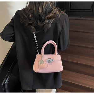 Detailed back view of pink leather bucket bag with silver chain strap and heart charm