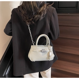 Detailed back view of a mini bucket bag with silver chain strap on a vintage staircase