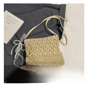 Detail eines beige gewebten Strohbeutels mit Sternmuster und Perlen-Schleifen-Deko