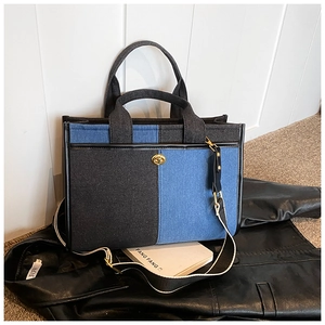 Détails du sac cabas en denim bicolore avec fermoir rotatif doré et bandoulière tissée