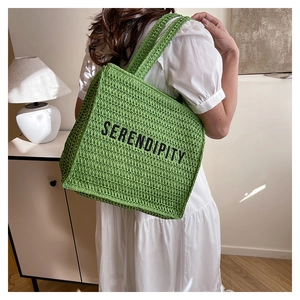 Close-up of green woven knit tote bag with SERENDIPITY text showing large capacity