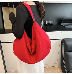 Detailansicht einer roten Nylon-Hobo-Tasche mit verstellbarer Metallschnalle am Gurt