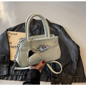 Close-up of light green lychee leather mini bucket bag with silver lock and chain