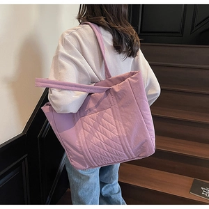 Close-up of lilac quilted tote bag showing wide shoulder strap and soft padded texture