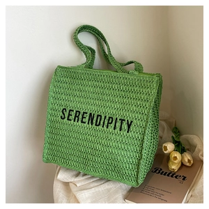 Detail of green crochet woven tote bag with Serendipity embroidery and rich texture