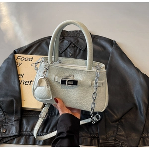 Detail of mint green textured bucket bag with silver chain and mini coin pouch