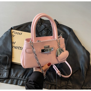 Close-up of pink litchi grain leather bucket bag with silver lock and heart charm