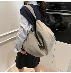 Detailansicht der grauen Canvas-Tasche mit verstellbarem Gurt und natürlichem Faltenwurf