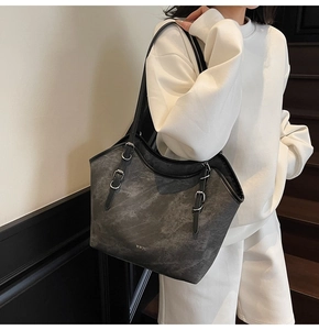 Detail of grey marble texture tote bag showing silver metal buckle straps and brand logo