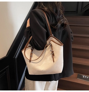 Detail of minimalist beige canvas tote bag with brown leather straps and WWTU branding