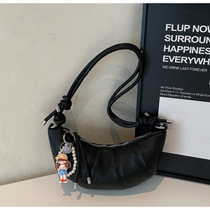 Detail of black pebbled leather crescent bag with knot strap and silver metallic hardware