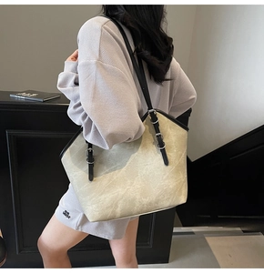 Detail of marble pattern tote bag with black leather straps and silver buckles