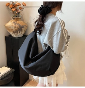 Große schwarze Hobo-Schultertasche für Damen, geräumige Nylon-Umhängetasche am Modell