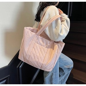 Pink quilted tote bag shown on shoulder featuring diagonal stitching and large capacity