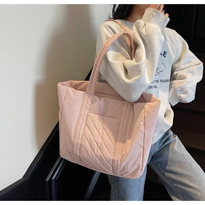 Pink quilted tote bag shown on model featuring textured stitching and large capacity