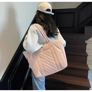 Detail of pink quilted tote bag showing large capacity and soft puffer fabric texture