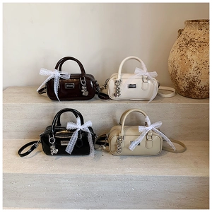 Detail of four stylish bowling handbags in brown, white, black and khaki with lace bows