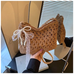 Detail der handgewebten Strohtasche mit Perlen-Spitzenschleife und Lochmuster