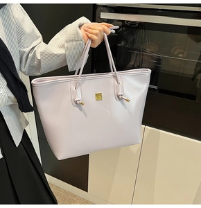 Close-up of a lavender oil wax leather tote bag with a golden square logo buckle