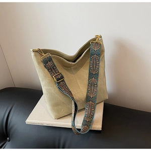 Detail of retro bucket bag with colorful ethnic embroidered wide strap and matte finish