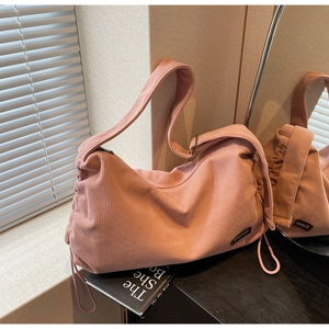 Detail of pink corduroy shoulder bag showing side drawstring and soft vintage texture
