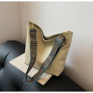 Detail of army green canvas hobo bag featuring ethnic jacquard strap and vintage hardware
