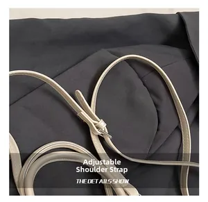 Detail of adjustable off-white leather shoulder strap with a polished metal buckle