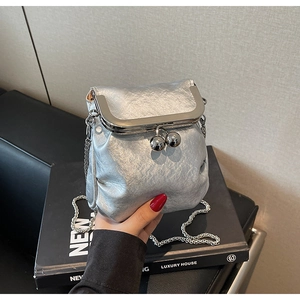 Detail of silver metallic bucket bag with ball clasp and sleek chain strap