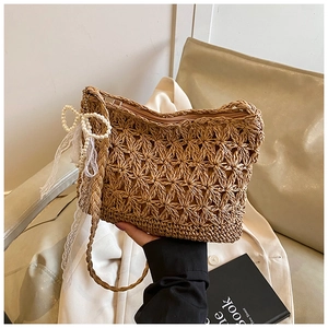 Detailaufnahme der Strohtasche mit Perlen-Schleife und hohler Blumenwebstruktur