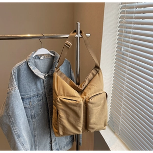 Detail of khaki tote bag with dual front zipper pockets and adjustable wide strap