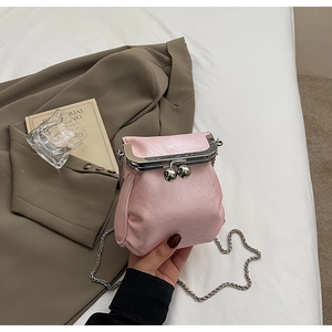 Detail of light pink pleated doctor bag with silver kiss-lock closure and chain strap