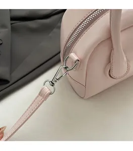 Detail of silver hardware buckle and handle attachment on pink leather bowling bag