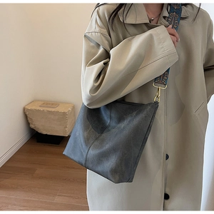 Détail du sac cabas gris foncé avec une bandoulière vintage tissée à fleurs bleues