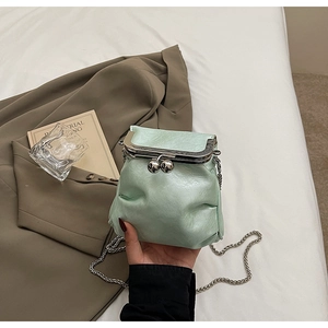 Detailed view of mint green pleated mini bag with silver metal chain and vintage clasp