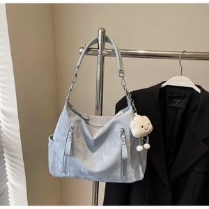 Détail du sac cabas gris clair avec deux fermetures éclair et un charme nuage en peluche