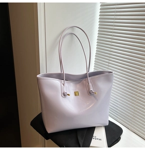 Detail of light purple oil-wax tote bag with golden metal logo and shiny glossy texture