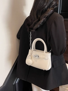 Mini cream bucket bag with lychee grain leather, silver chain, and heart charm on model