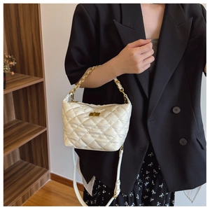 Détail du sac bandoulière blanc matelassé avec chaîne dorée et fermoir pivotant chic