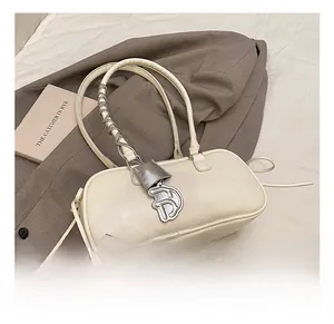 Detail of white butterfly baguette bag with silver D-pendant and chain-wrapped strap