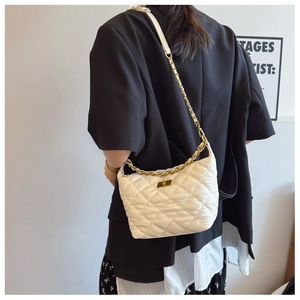 Détail du sac bandoulière blanc matelassé avec chaîne dorée et fermoir rotatif en métal