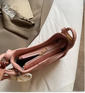 Detailed view of pink bucket bag interior with smooth zipper and pearl lace charm