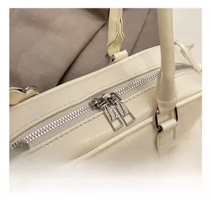 Close-up of double silver zippers on white leather baguette bag with high-quality hardware