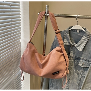 Detailed view of pink corduroy hobo bag featuring adjustable strap and metal buckle detail